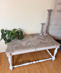 WoodUBend Trim #TR716 (Set of 2) is the perfect mouldable embellishment for any project!  A coffee table with white chalk painted legs and a brown wooden top sitting on a wooden floor in front of a white wall.  The top front of the table has white chalk painted WoodUbend across it.  A green plant and two brown chalk painted candlesticks sit on top of the table.  A white sign with black writing is hanging on the wall to the right of the table.