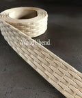 WoodUBend Trim #TR716 (Set of 2) is the perfect mouldable embellishment for any project!  A roll of WoodUbend trim sitting on a brown table, unrolling at one end.
