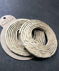 WoodUBend Trim #TR722 (Set of 2) is the perfect mouldable embellishment for any project!  Two rolls of WoodUbend sitting on top of a brown round cardboard cutout with WoodUbend WUBTR722 printed at the top; all sitting on a black table.